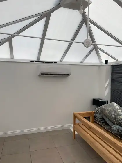 Wall-mounted air conditioner keeping a glass-roof conservatory cool