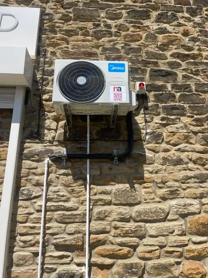 Outdoor unit mounted on a natural stone wall